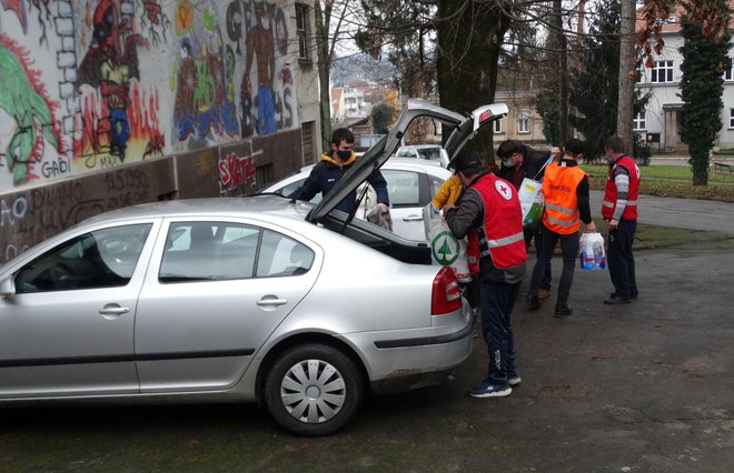 Djelatnici Crvenog križa pomažu građanima iskrcati donacije iz automobila/Foto: Dijana Puhalo