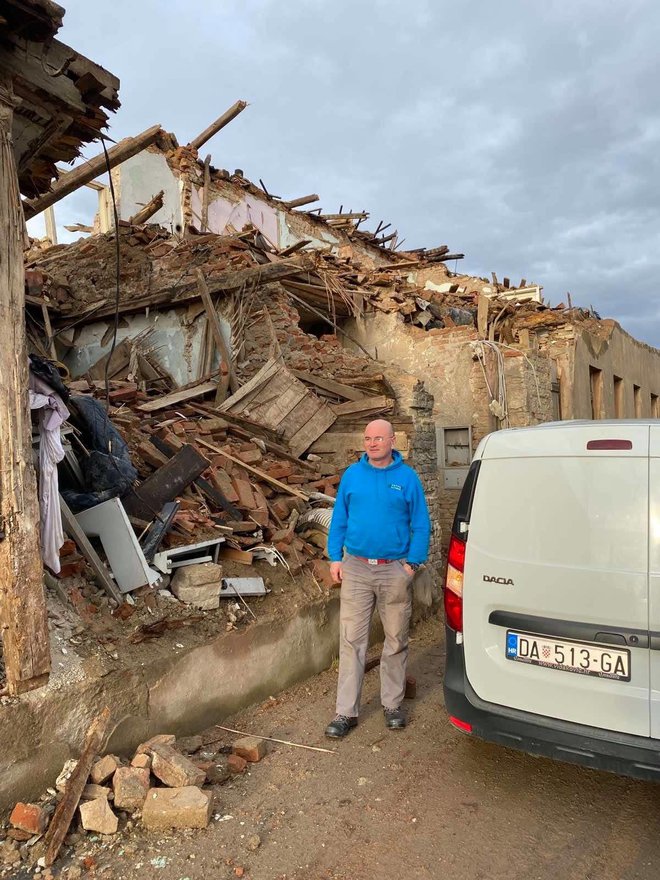 Djelatnik Darkoma ispred potpuno razrušene kuće u Glini/Foto: Vladimir Lukačin