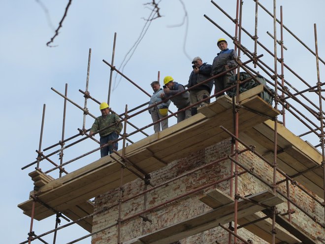 Radnici na vrhu crkvenog tornja koji su namjestili su krovnu konstrukciju na svoje mjesto / Foto: Mato Pejić
