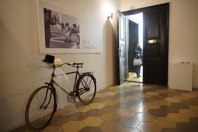 Ulaz u galeriju sa fotografijom Eve i Alberta na biciklu odmah nakon vjenčanja u Rimu te s izloženim starim biciklom, cilindar šeširom i vjenčanim buketom izloženim ispod fotografije/Foto: Nikica Puhalo
